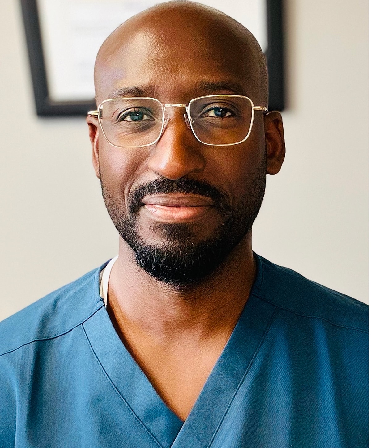 Health professional in scrubs, smiling confidently.