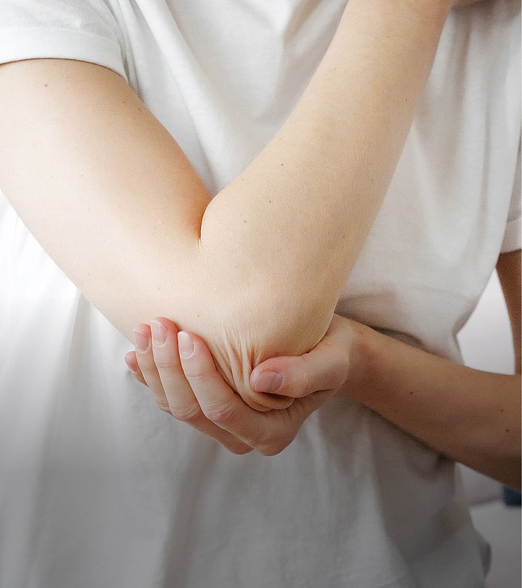 Person holding their elbow with one hand.
