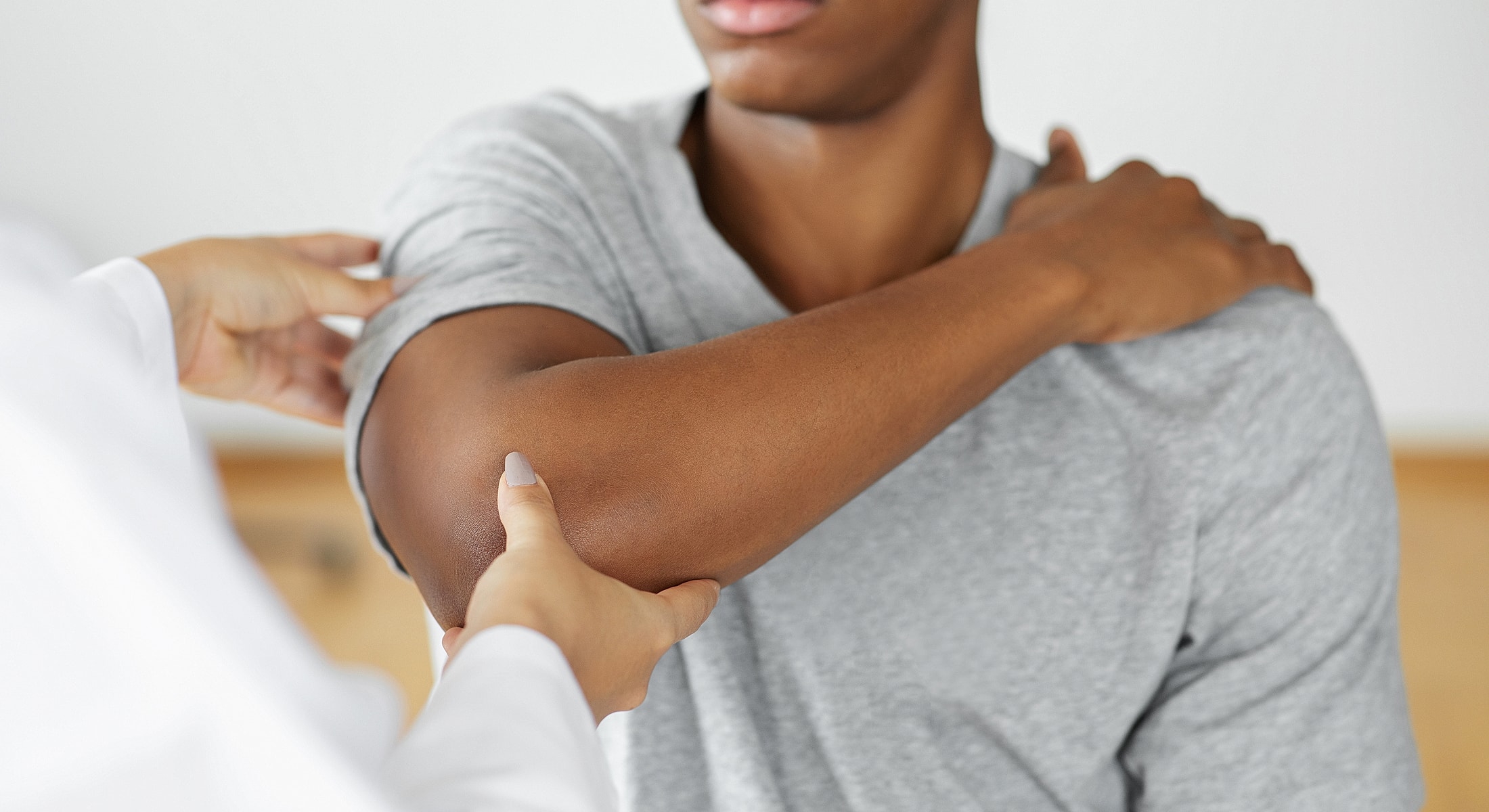 Healthcare professional examining patient's elbow joint.
