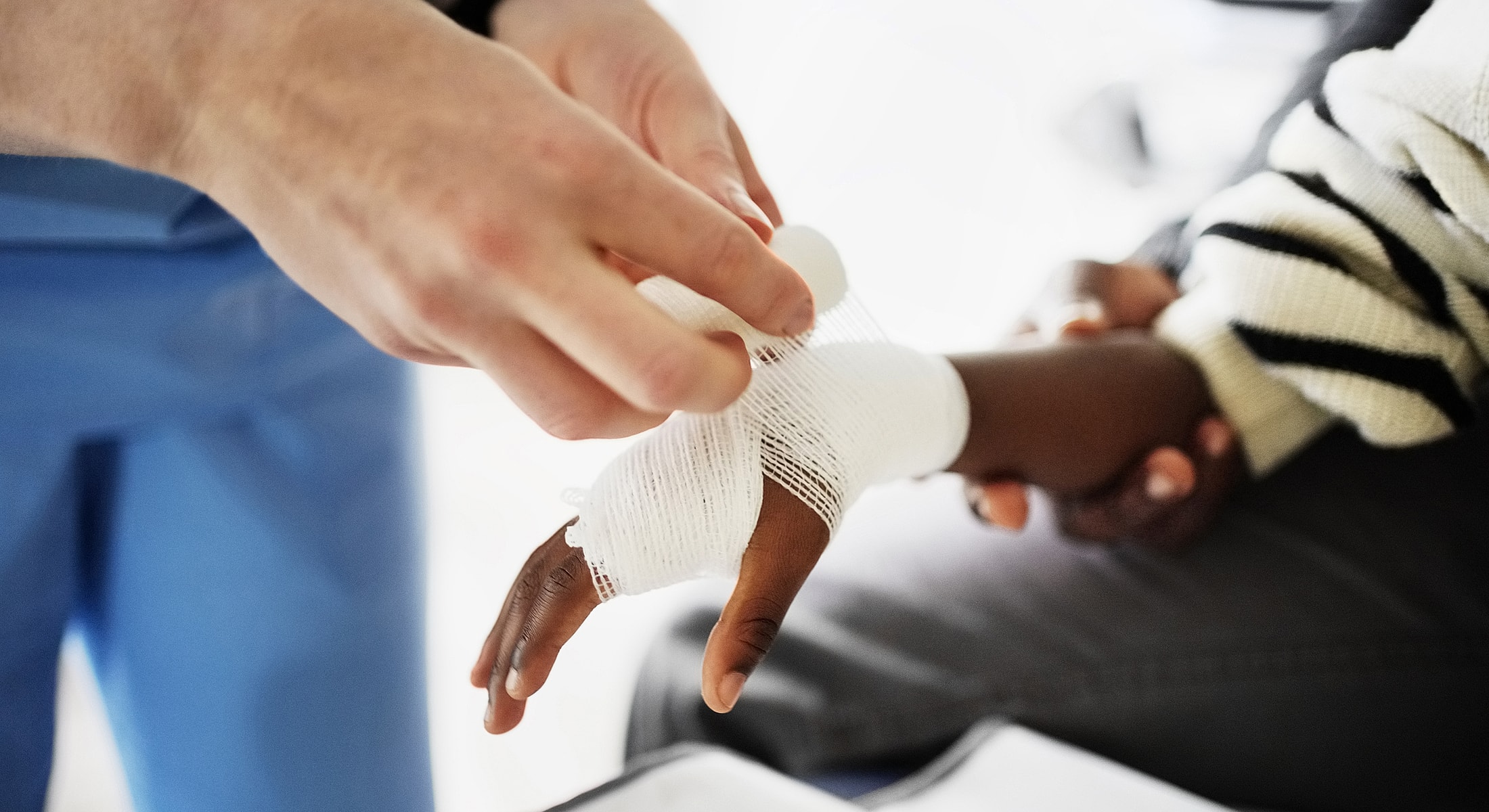 Applying a bandage to a wounded hand.